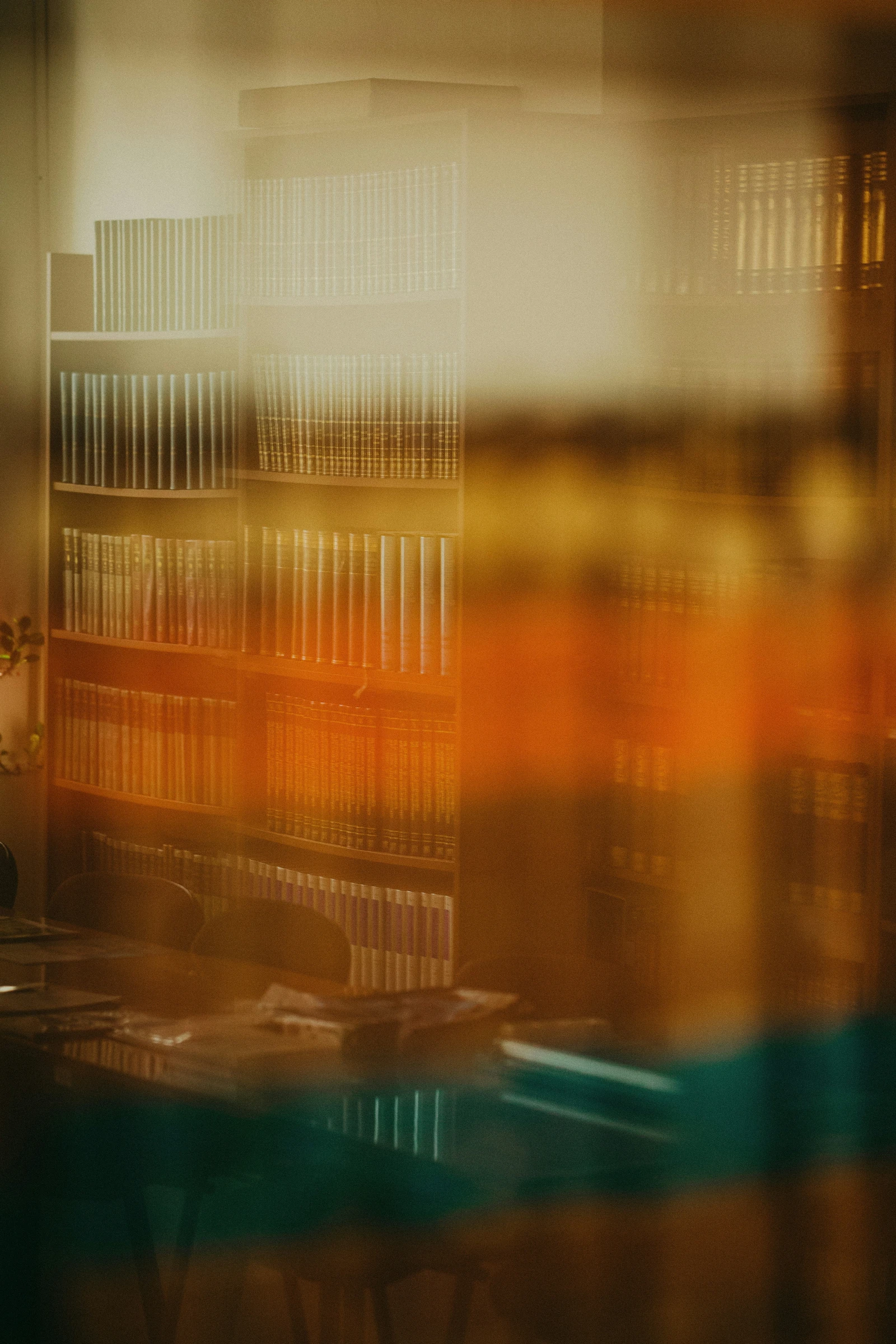Rayonnages de livres juridiques, vus en flou à travers une vitre